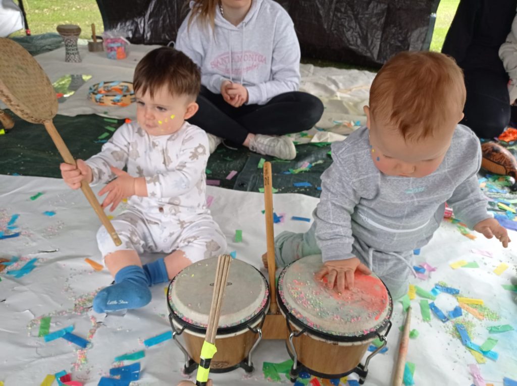 Babies playing drums in outdoors creative play session