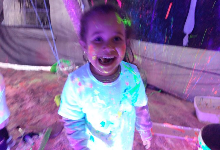 Young child in tent at Starcatchers' Neon Baby Rave