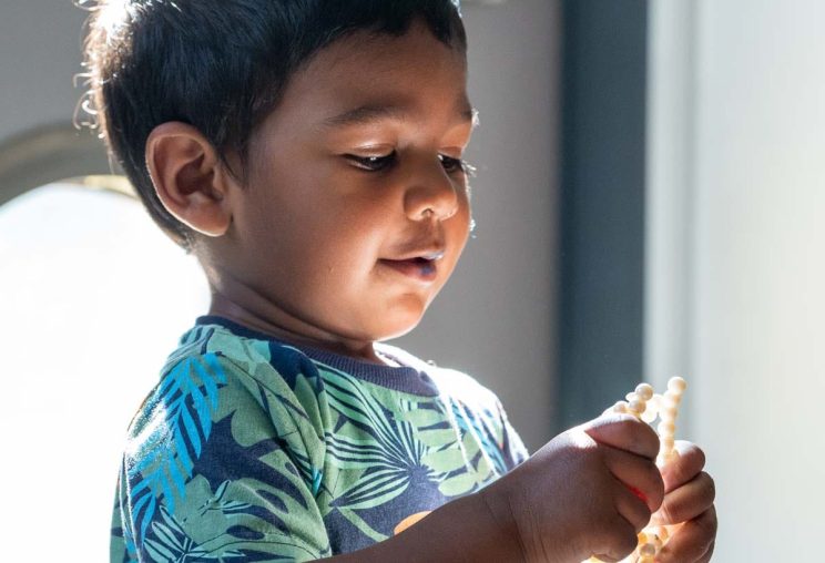 A young boy looking at a light in his hands